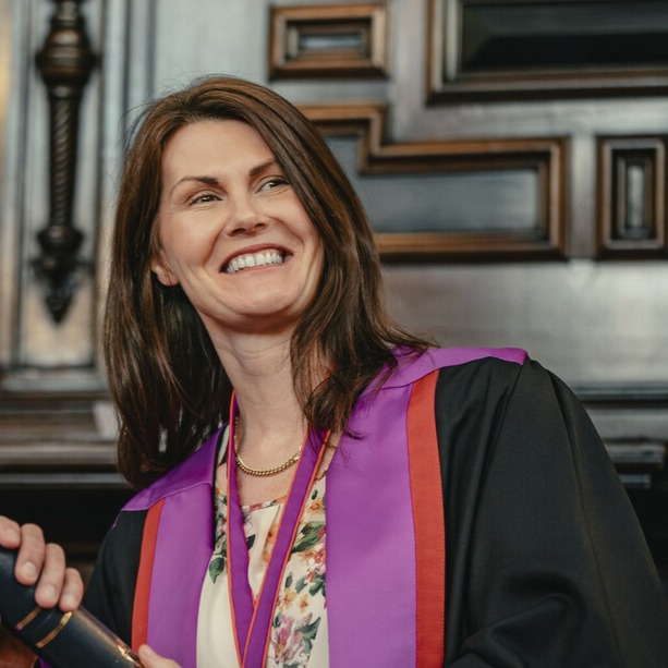 Deborah Wilson smiling in official College robes