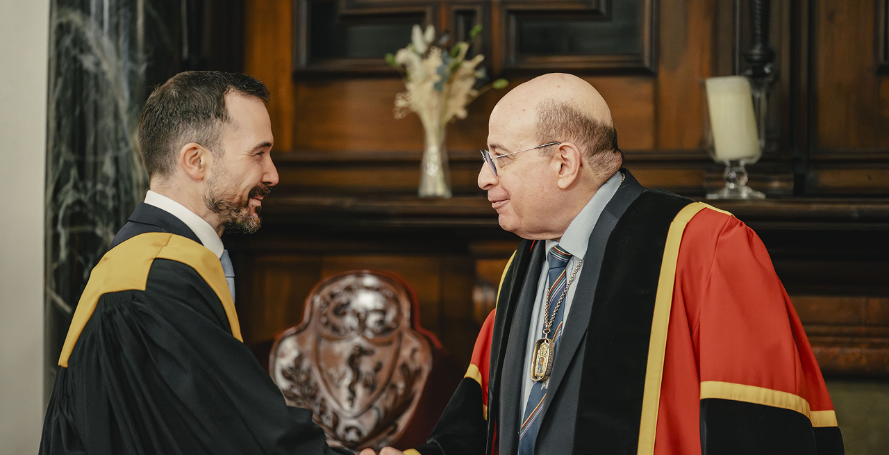 Two members of RCPSG in academical dress shaking hands