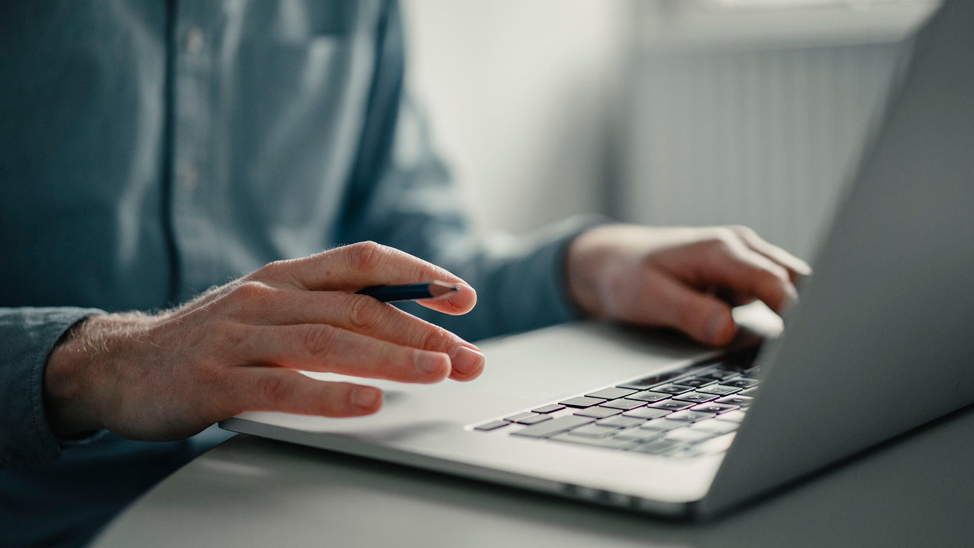 A pair of hands typing at a keyboard
