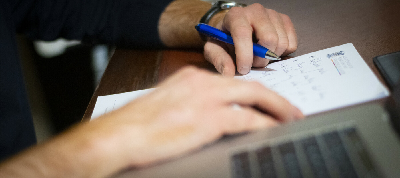 Close up of a hand writing out research