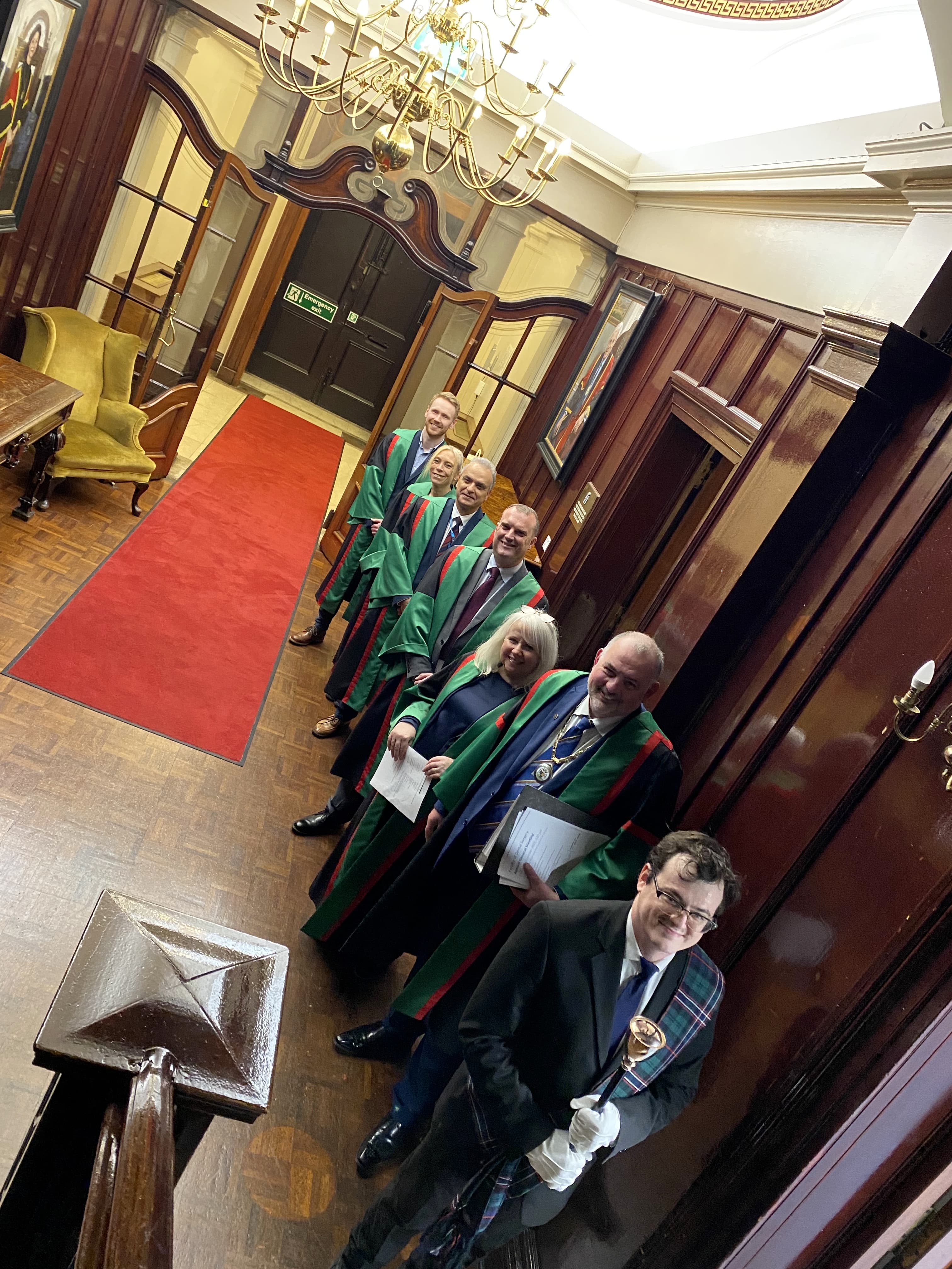 A group of dental members lined up in ceremonial robes
